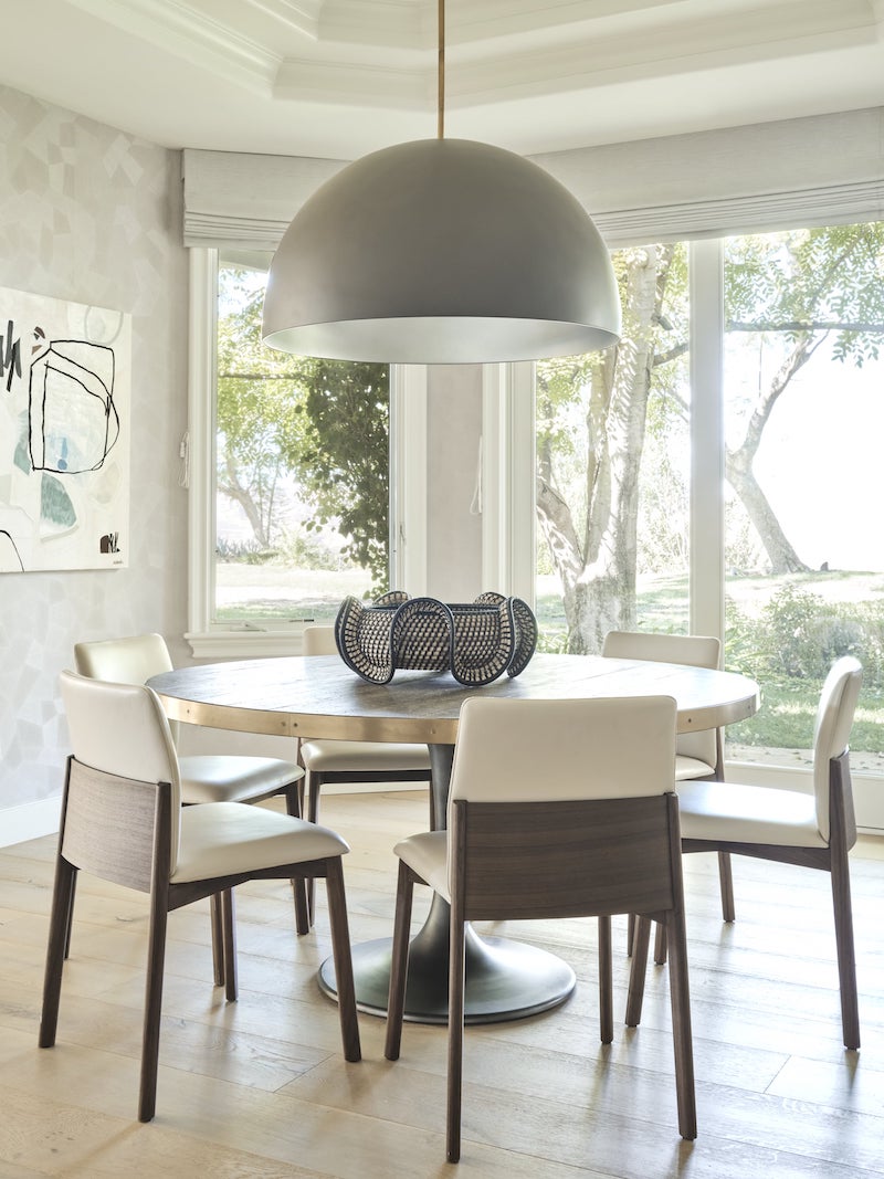 Round Dinner Table With Six White Chairs Around It